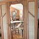Large antique wardrobe made of solid raw wood and natural caning.