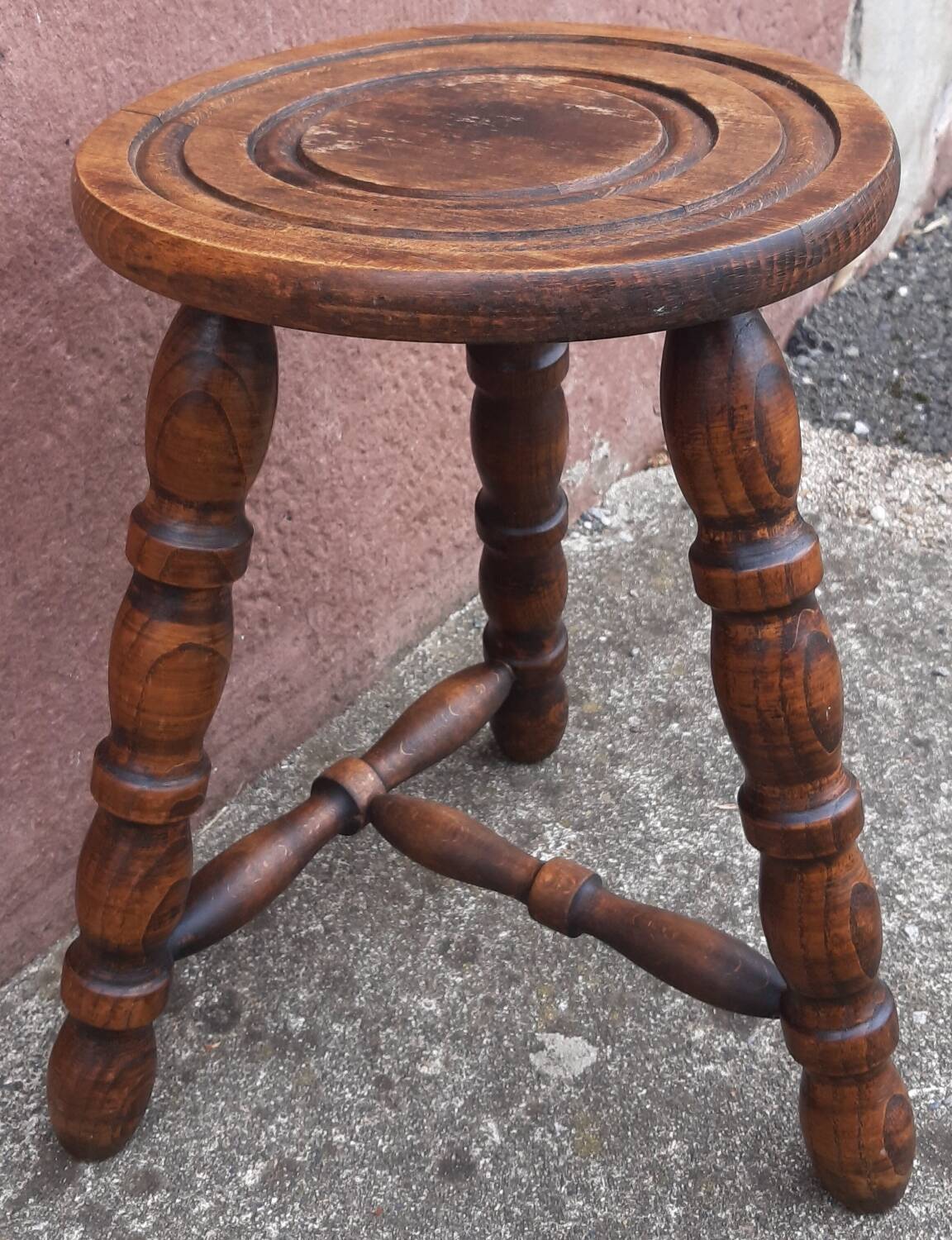 Low wooden tripod stool.