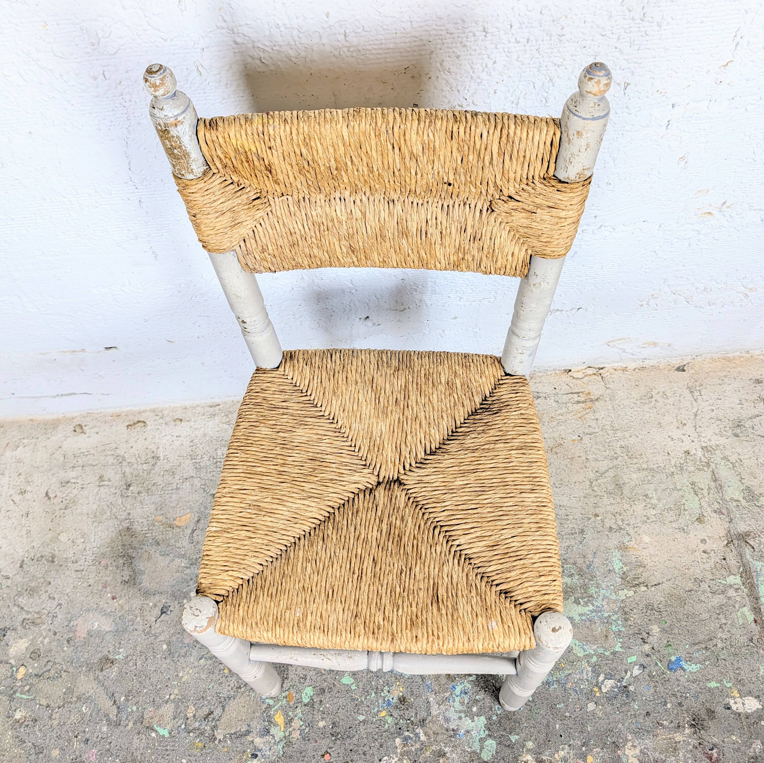 Rustic chair made of turned wood and straw.