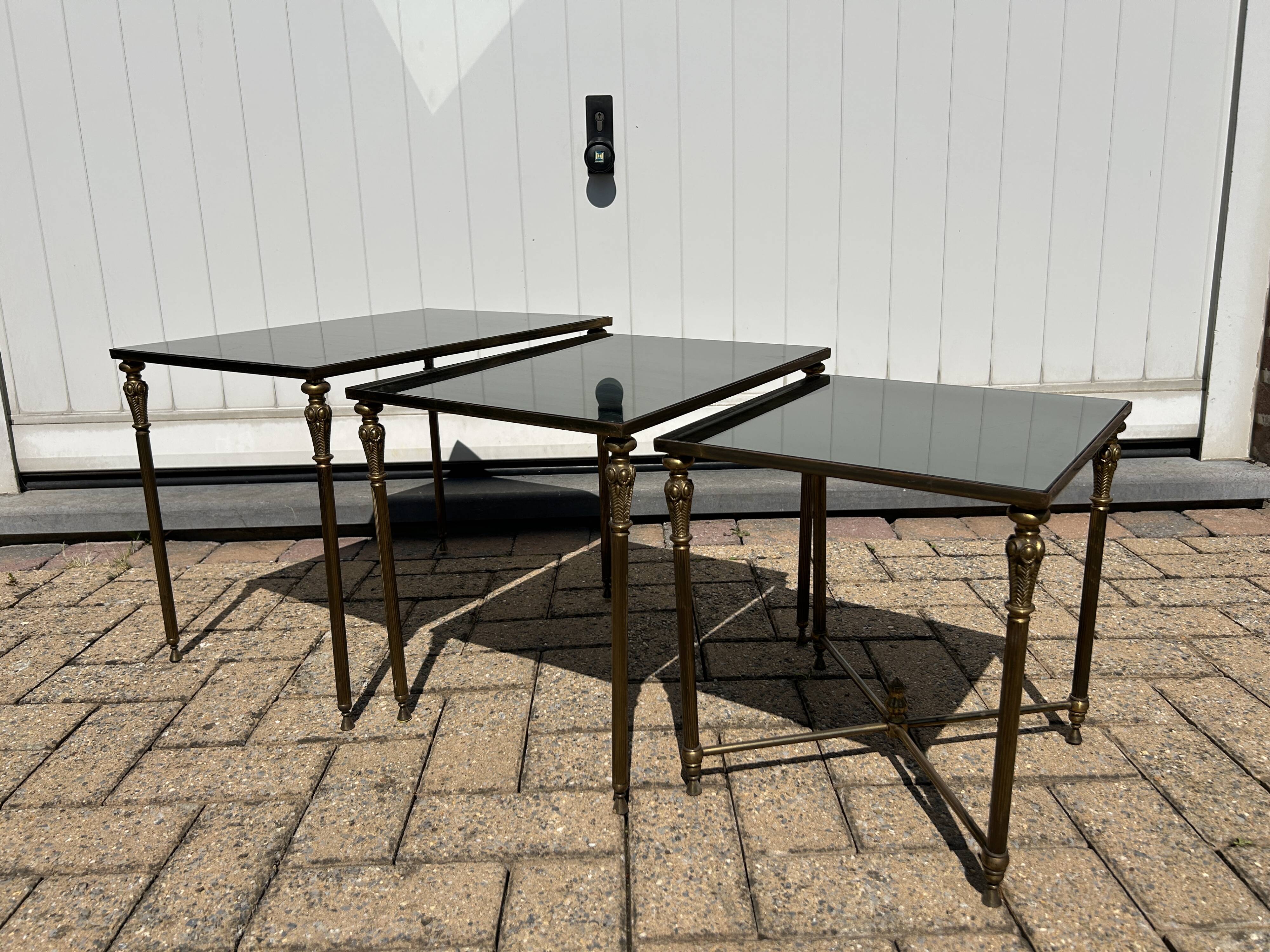 Nested tables in gilded brass in the style of Maison Charles.