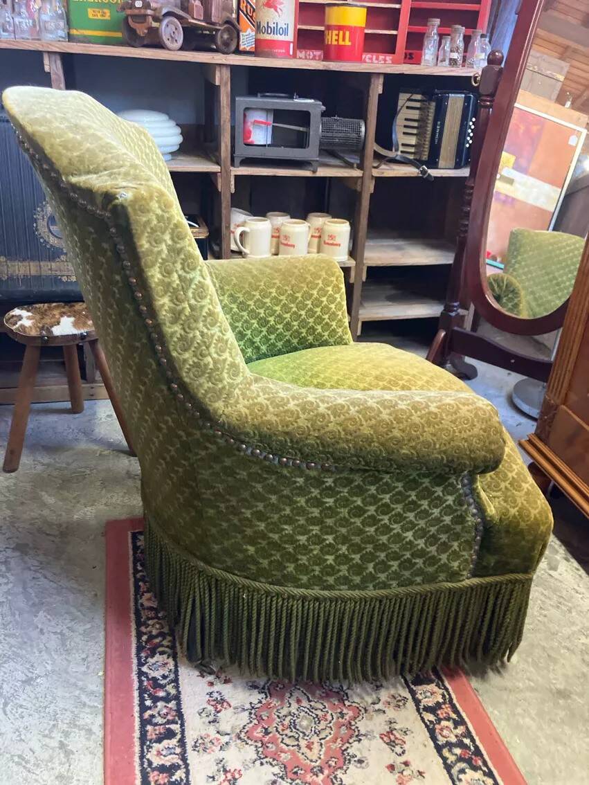 Green velvet toad armchair with wheels and fringes