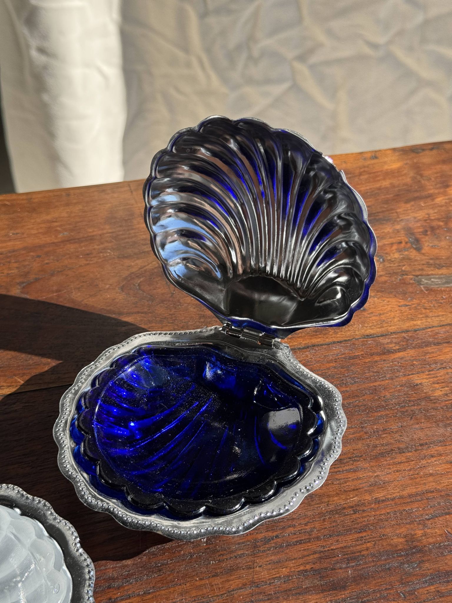 Vintage silver-plated shell butter dish with blue bowl.