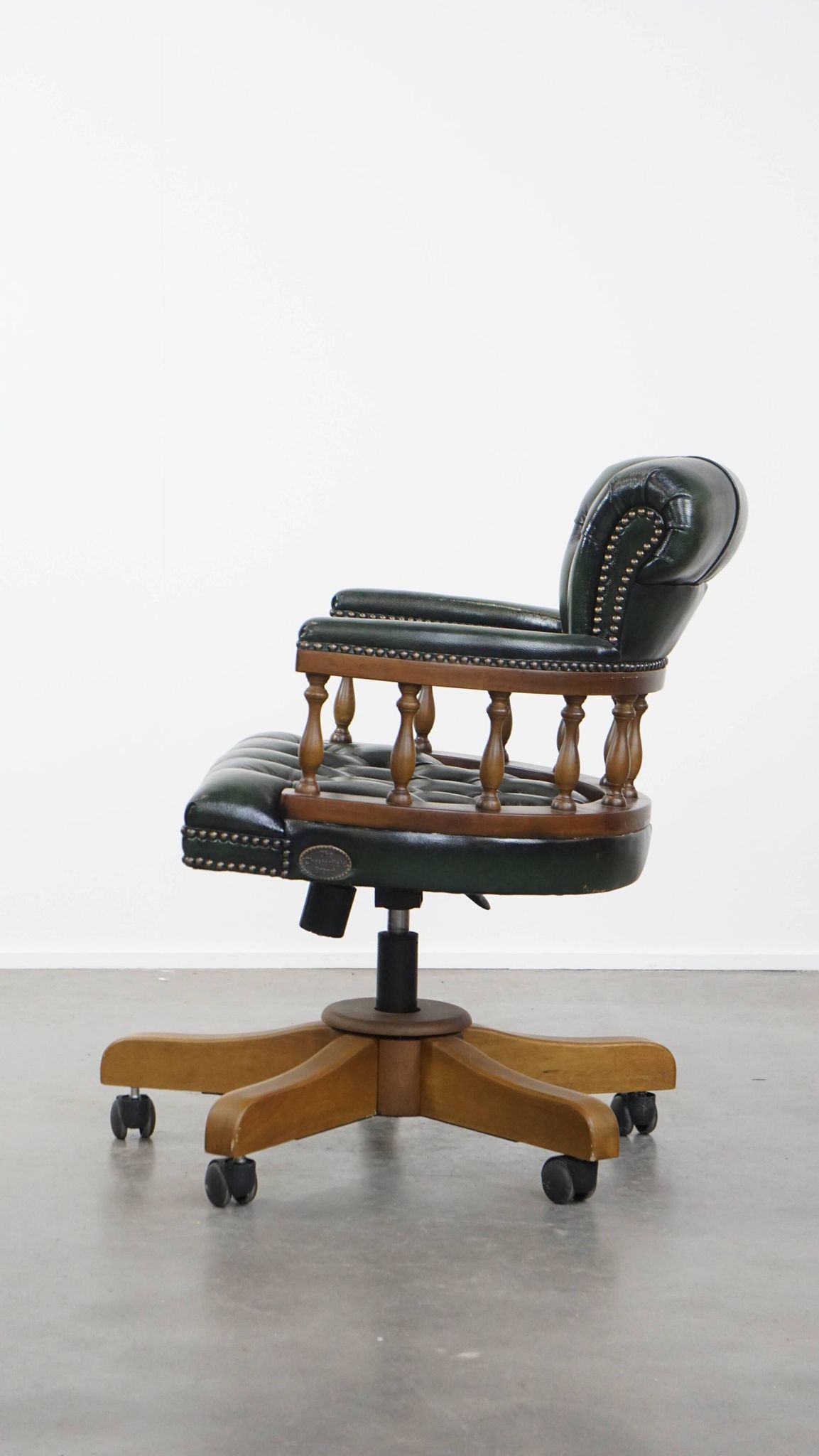 Dark green cowhide leather and wood chesterfield office chair on wheels