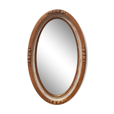 Grand miroir ovale à glace biseautée en stuc et bois à décor de fleurs