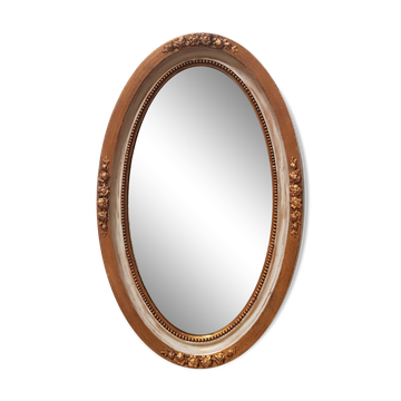 Grand miroir ovale à glace biseautée en stuc et bois à décor de fleurs