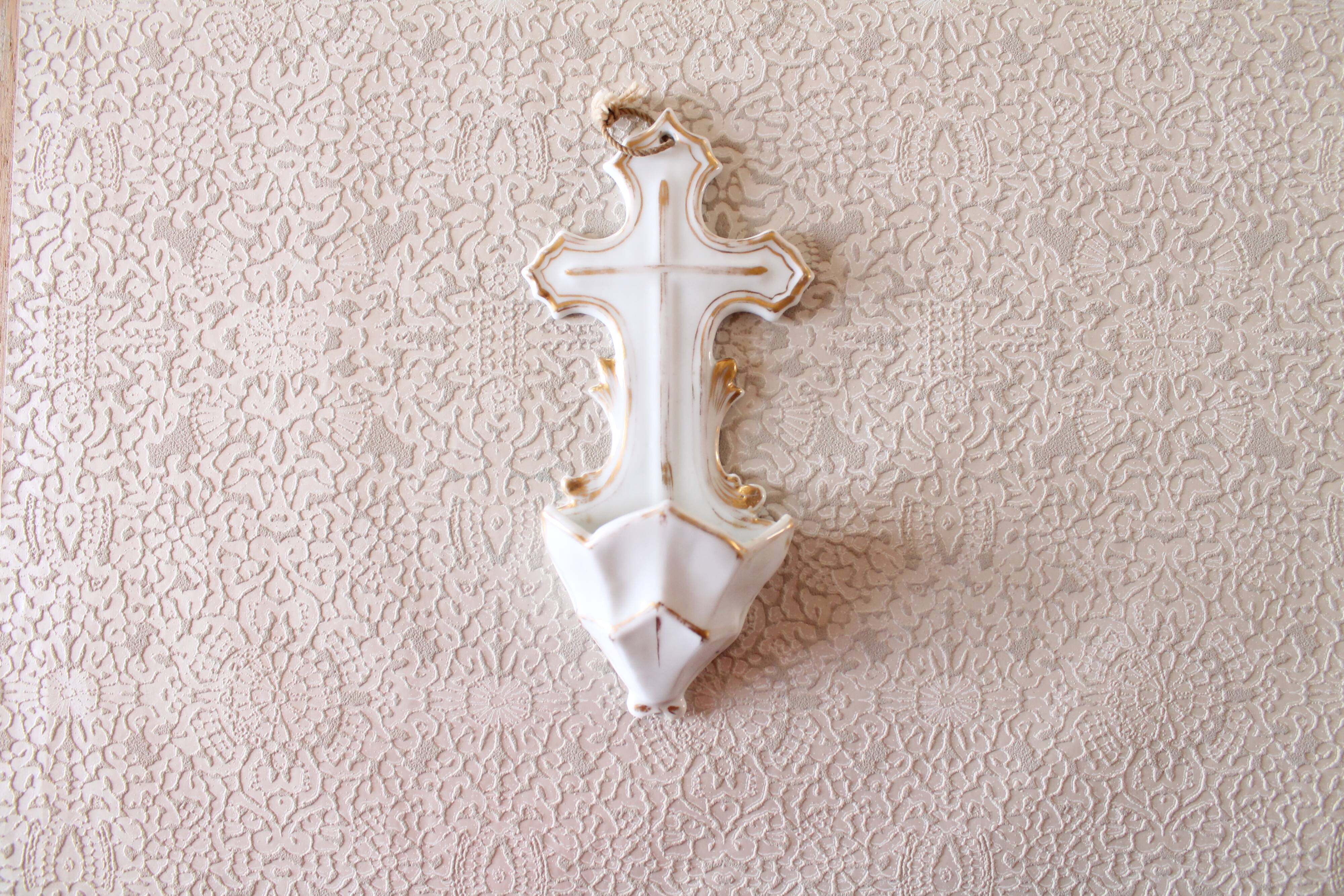 Antique holy water font in white porcelain biscuit.