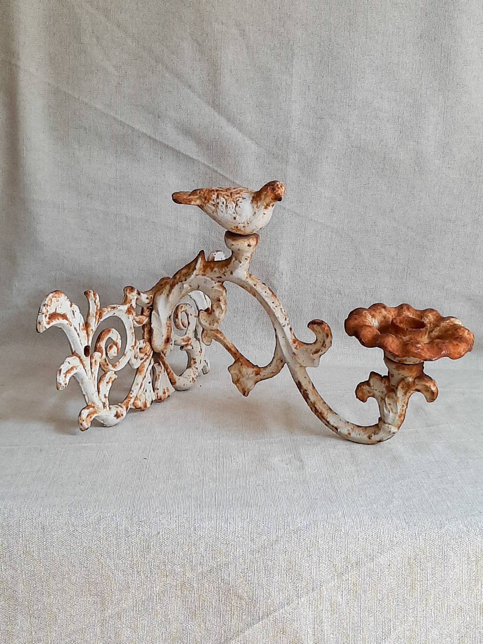 Wall lamp in antique cast iron with bird and scroll decorations.
