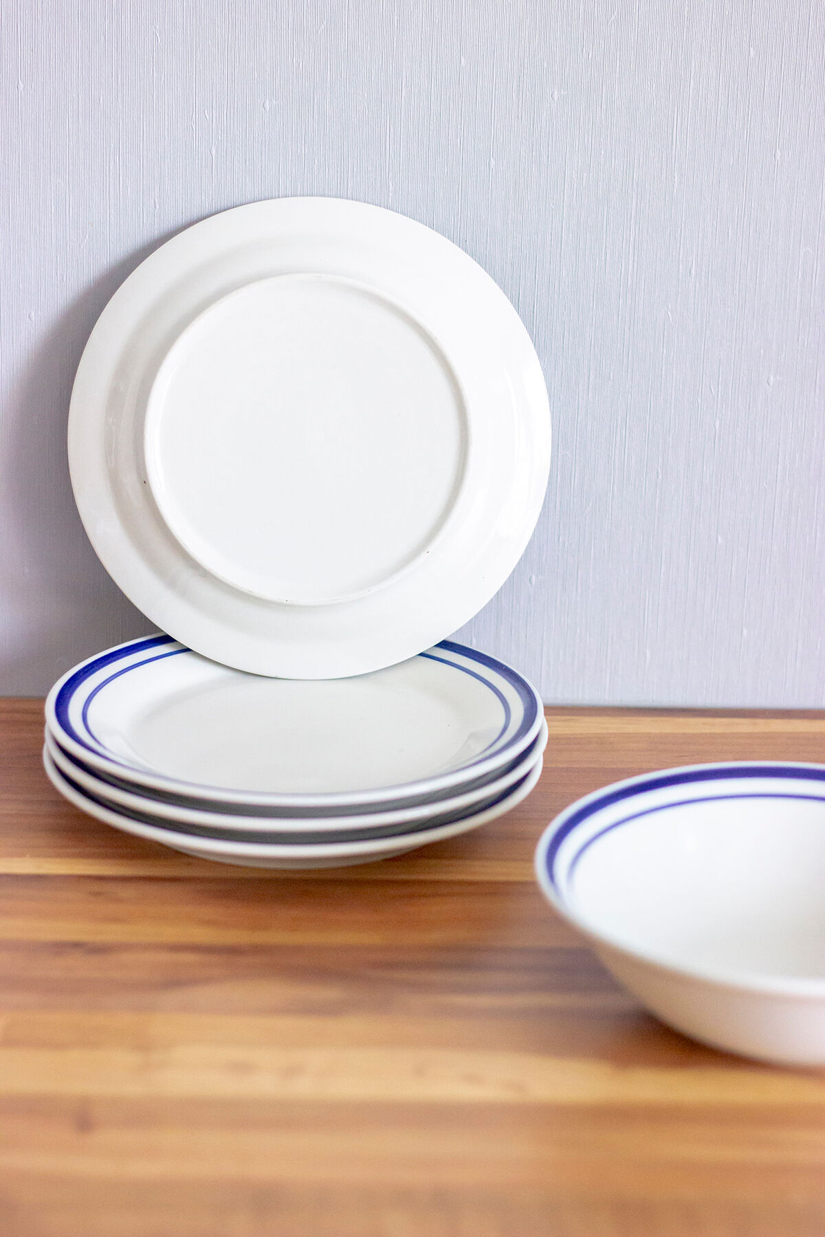 4 blue bordered dessert plates and a matching bowl