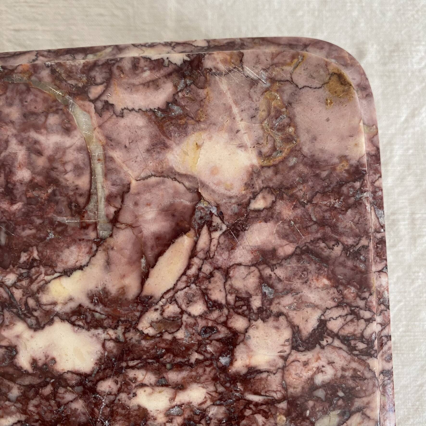 Pink marble trivet with brass ball feet.