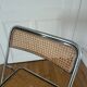 Vintage folding chair in metal and cane.