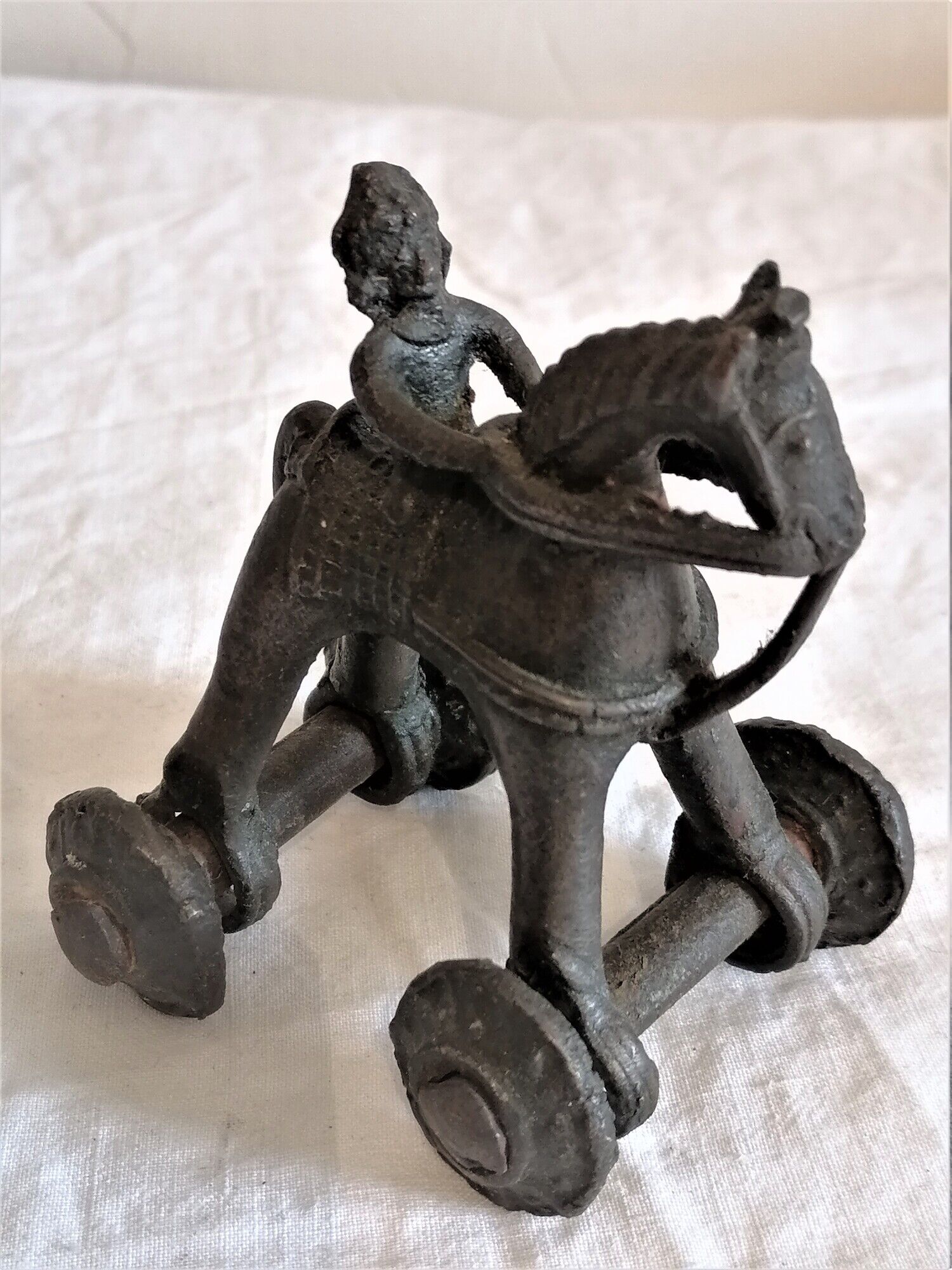 Old child's toy. Horse with bronze wheels. Ethnic object.