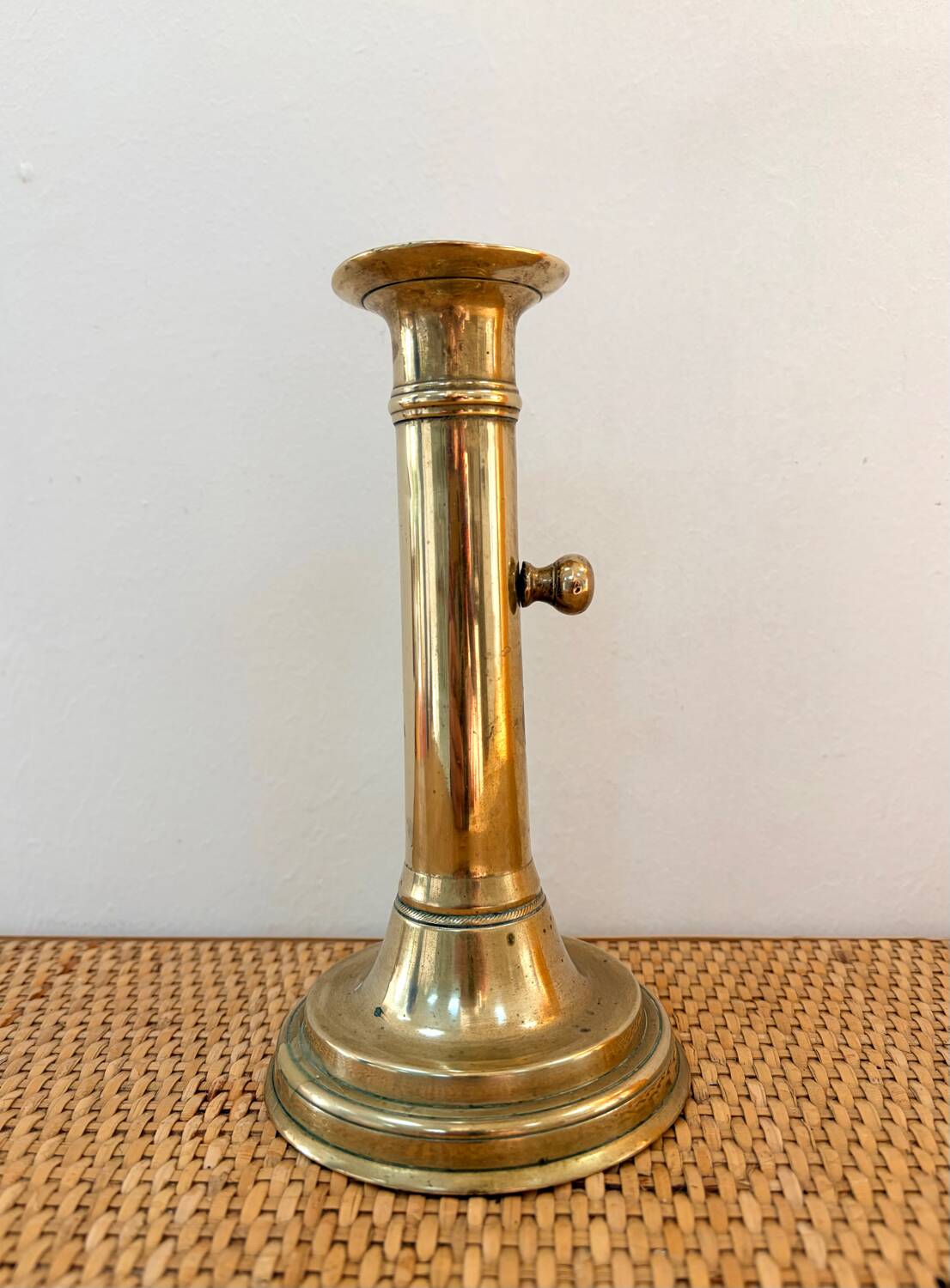 Old brass candlestick with push button.