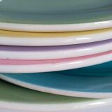 Seven pastel-colored plates mixed with vintage earthenware