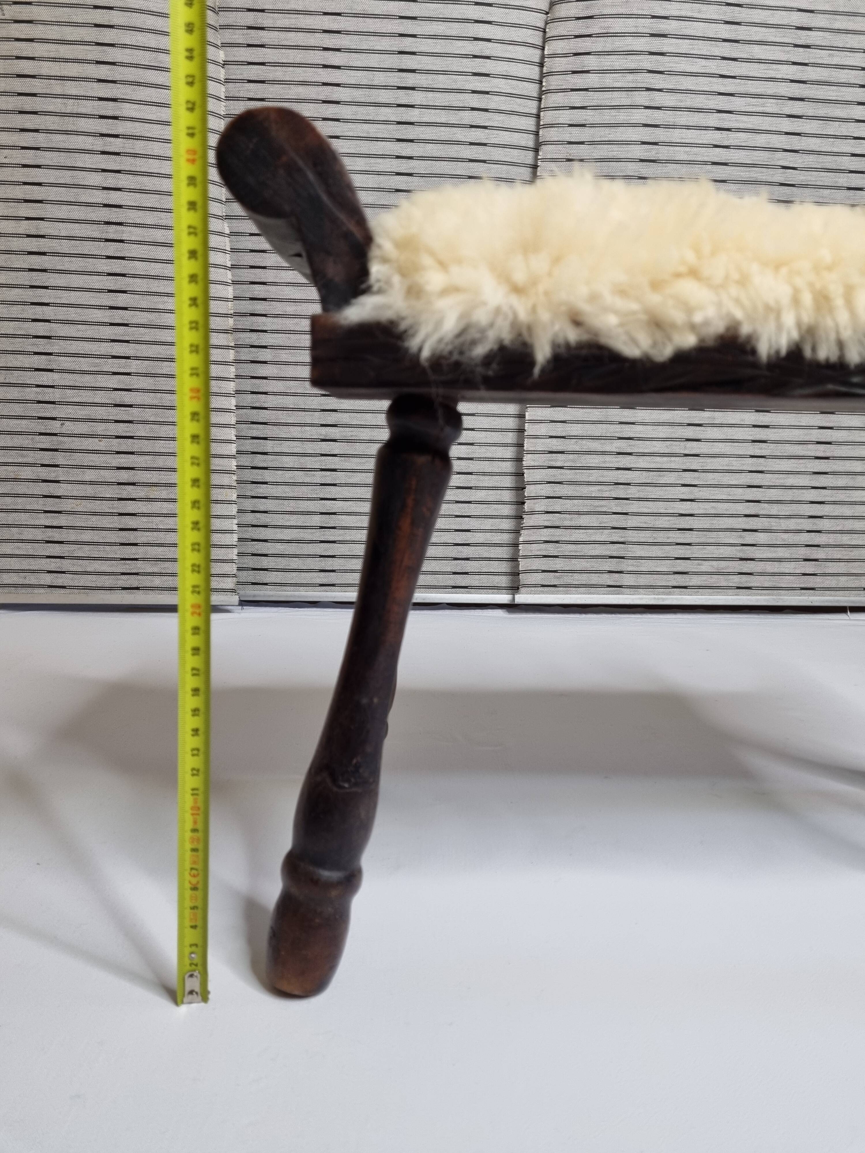 Carved wooden stool covered with Celtic-style sheepskin