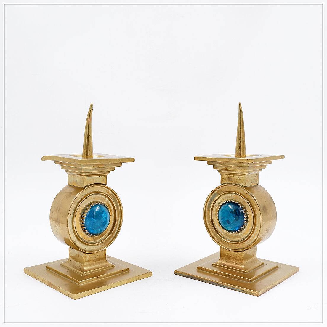 Pair of brass candlesticks decorated with a blue stone inlaid in the center