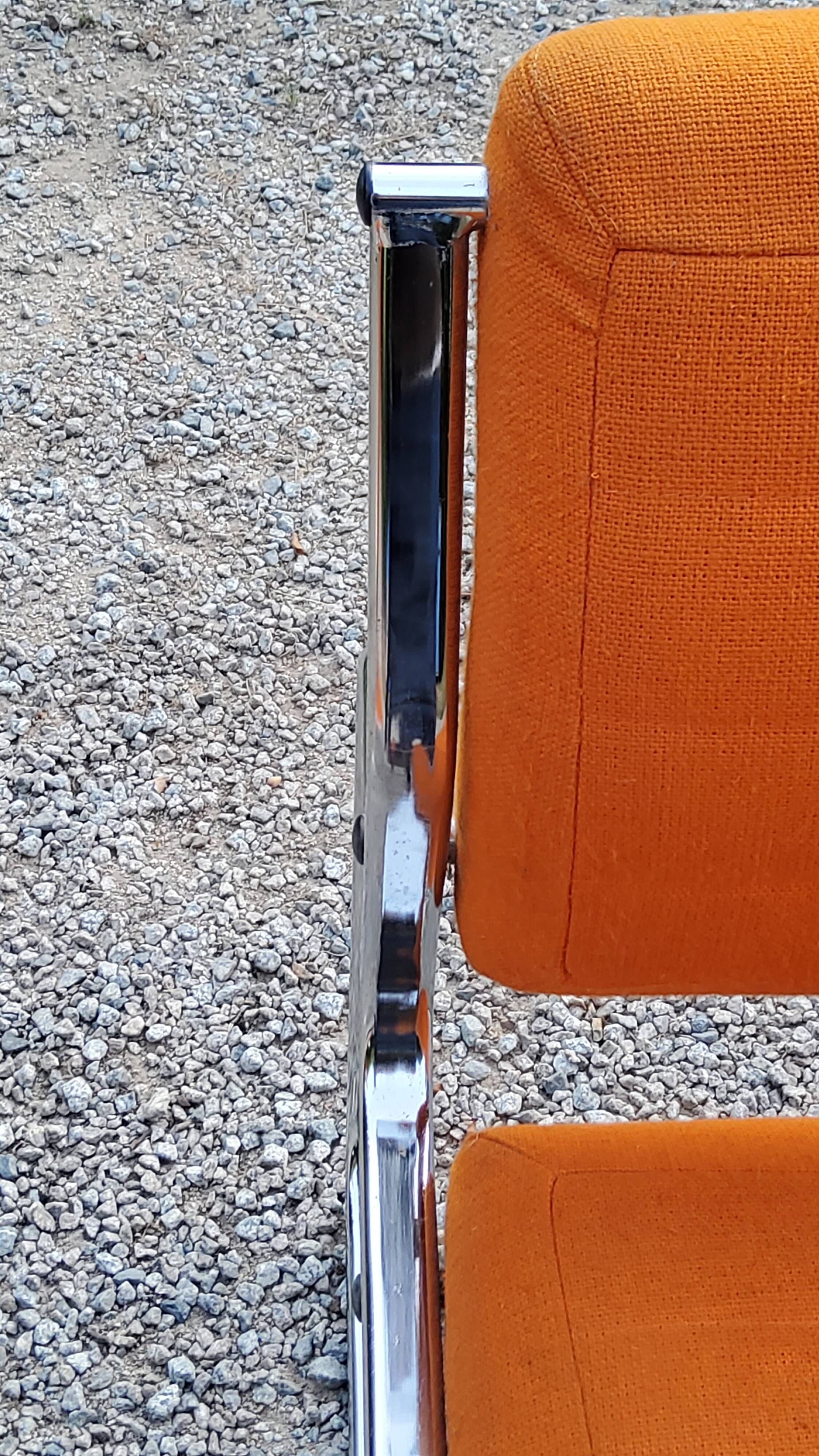 Pair of designer armchairs in orange fabrics and chrome tubes from the 70s