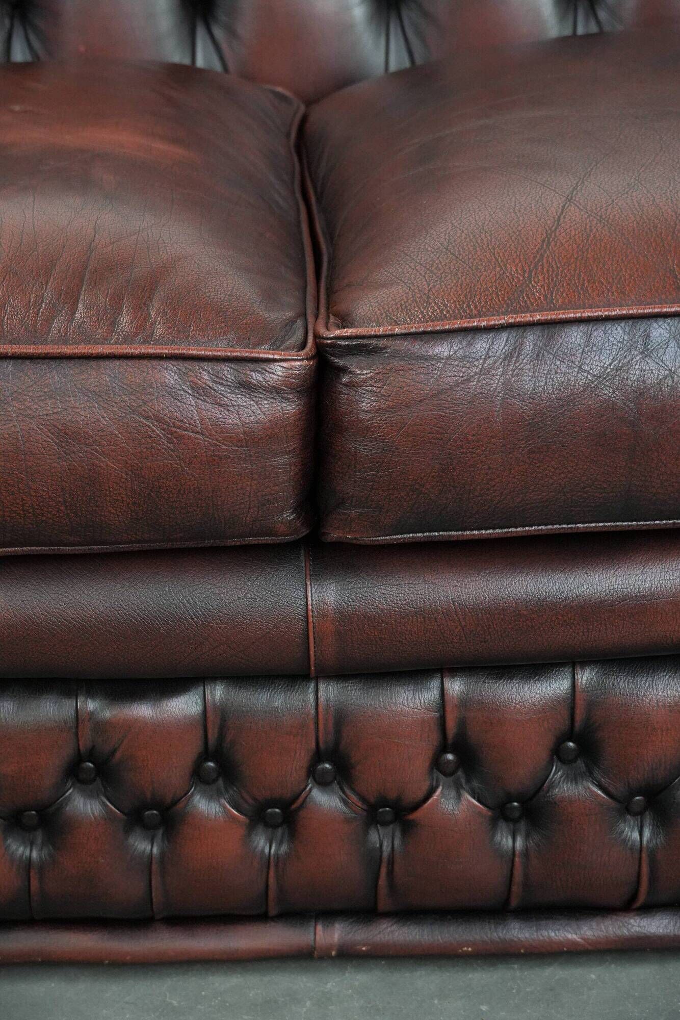 Classic cowhide Chesterfield sofa in English style with red/brown colours