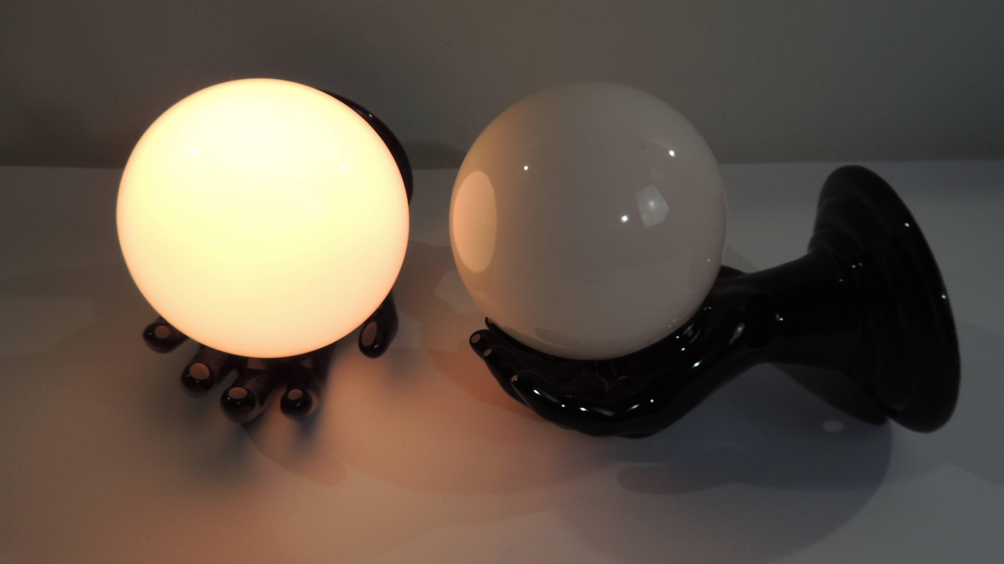 Paire d’appliques mains noires tenant un globe en opaline, années 70