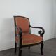 Restoration armchair in mahogany with cross arms and orange fabric.