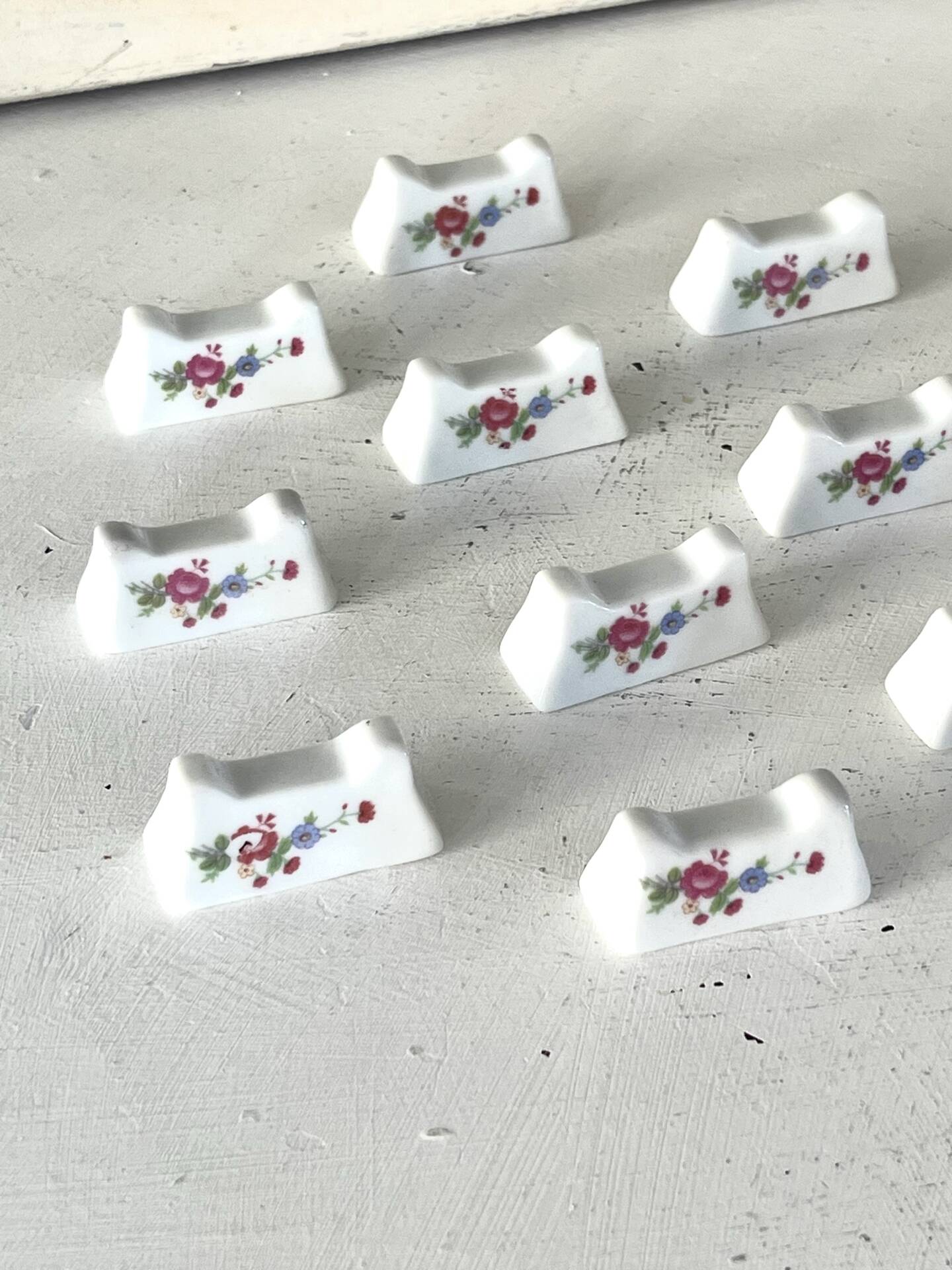 Ensemble de 12 repose-couteaux en porcelaine française avec motifs floraux