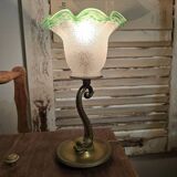 Small table lamp with a brass fish base and a tulip shade with green edges.