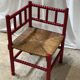 Red turned wood corner chair with rush seating