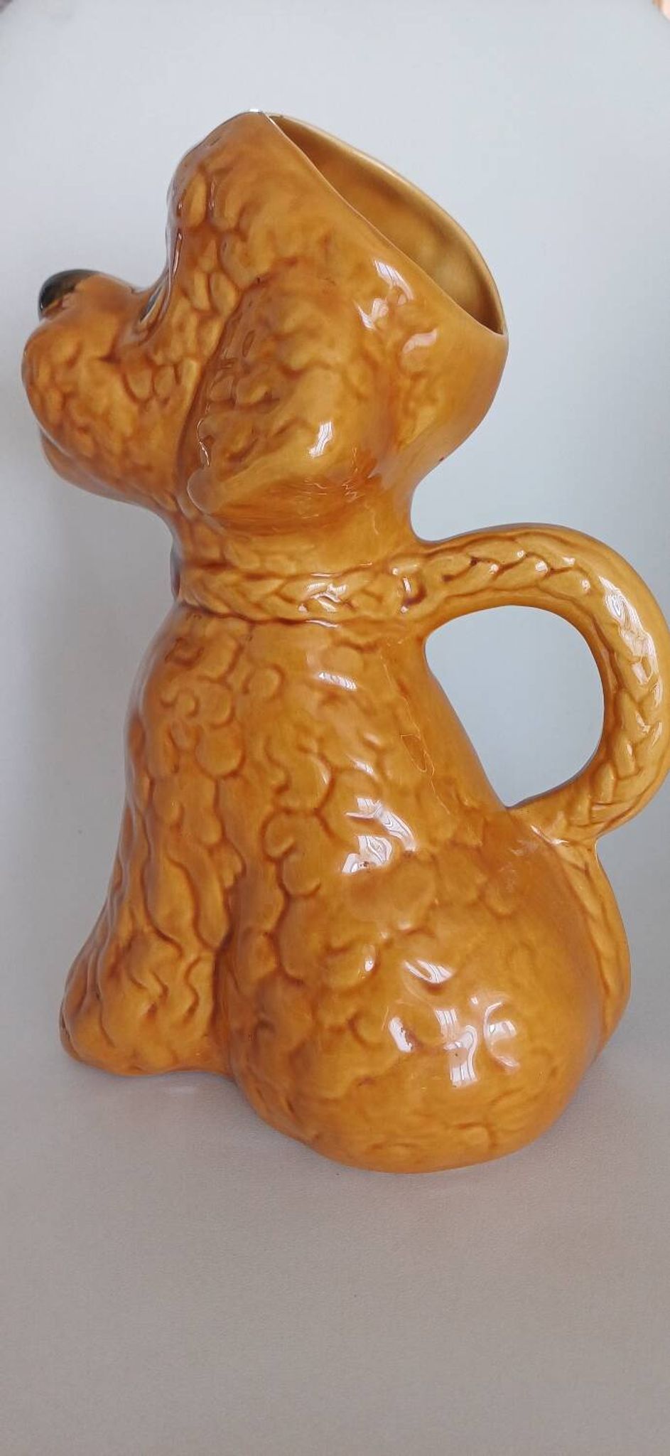 Ancient ceramic pitcher in the shape of a poodle.