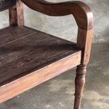 Small antique Indonesian bench in carved teak with plant and floral motifs.