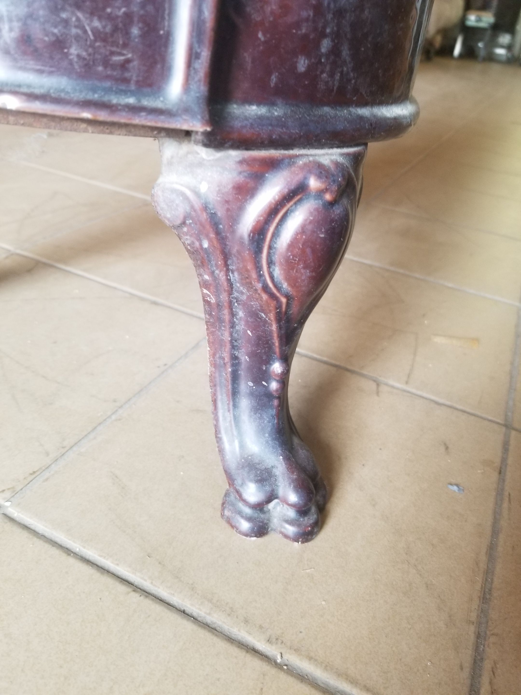 Old compact wood stove in enamelled cast iron with tripod feet with Lion's legs