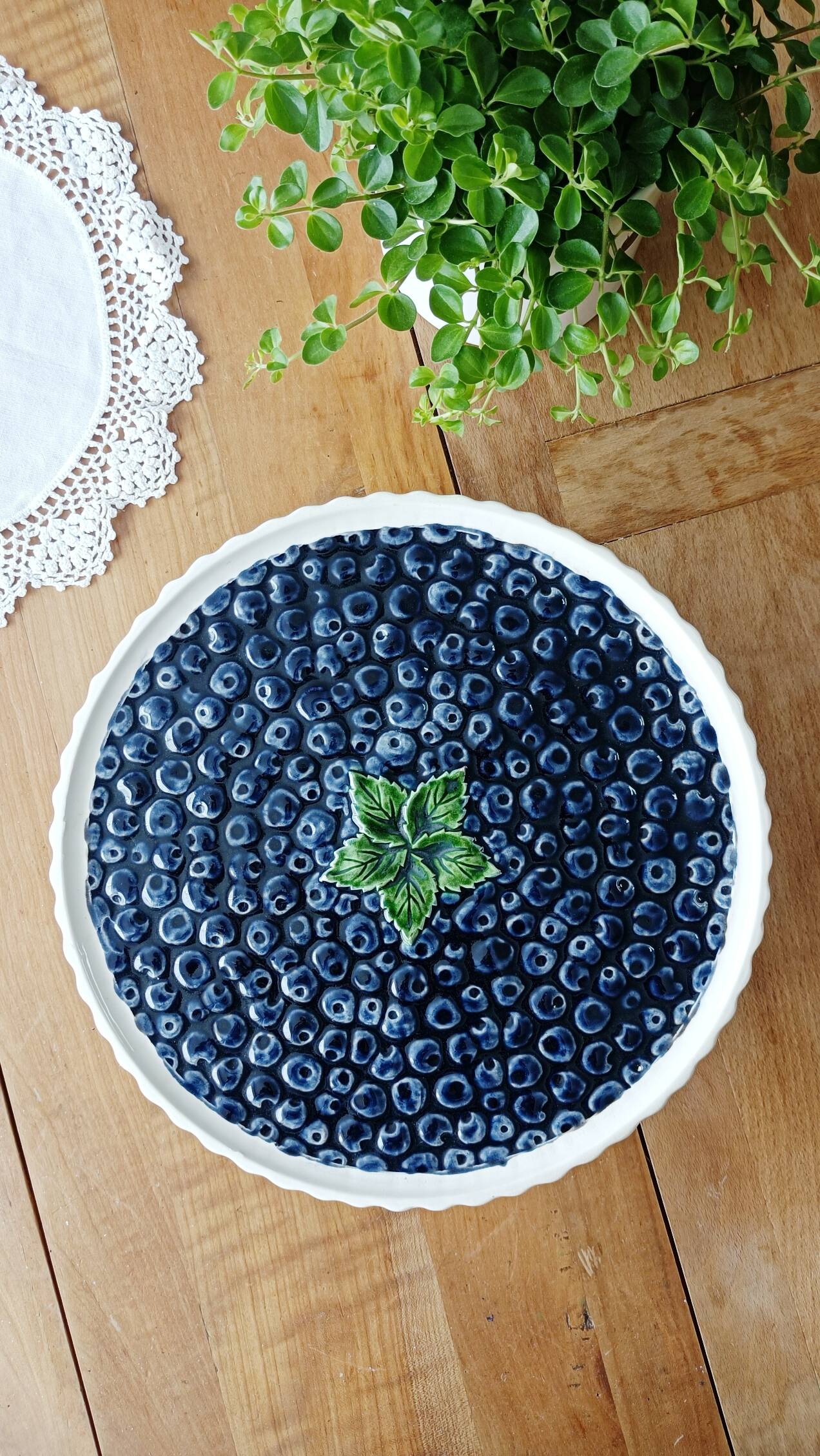 Pie dish on foot, in slip with blackberry decoration
