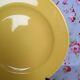 Old round plate in yellow faïence