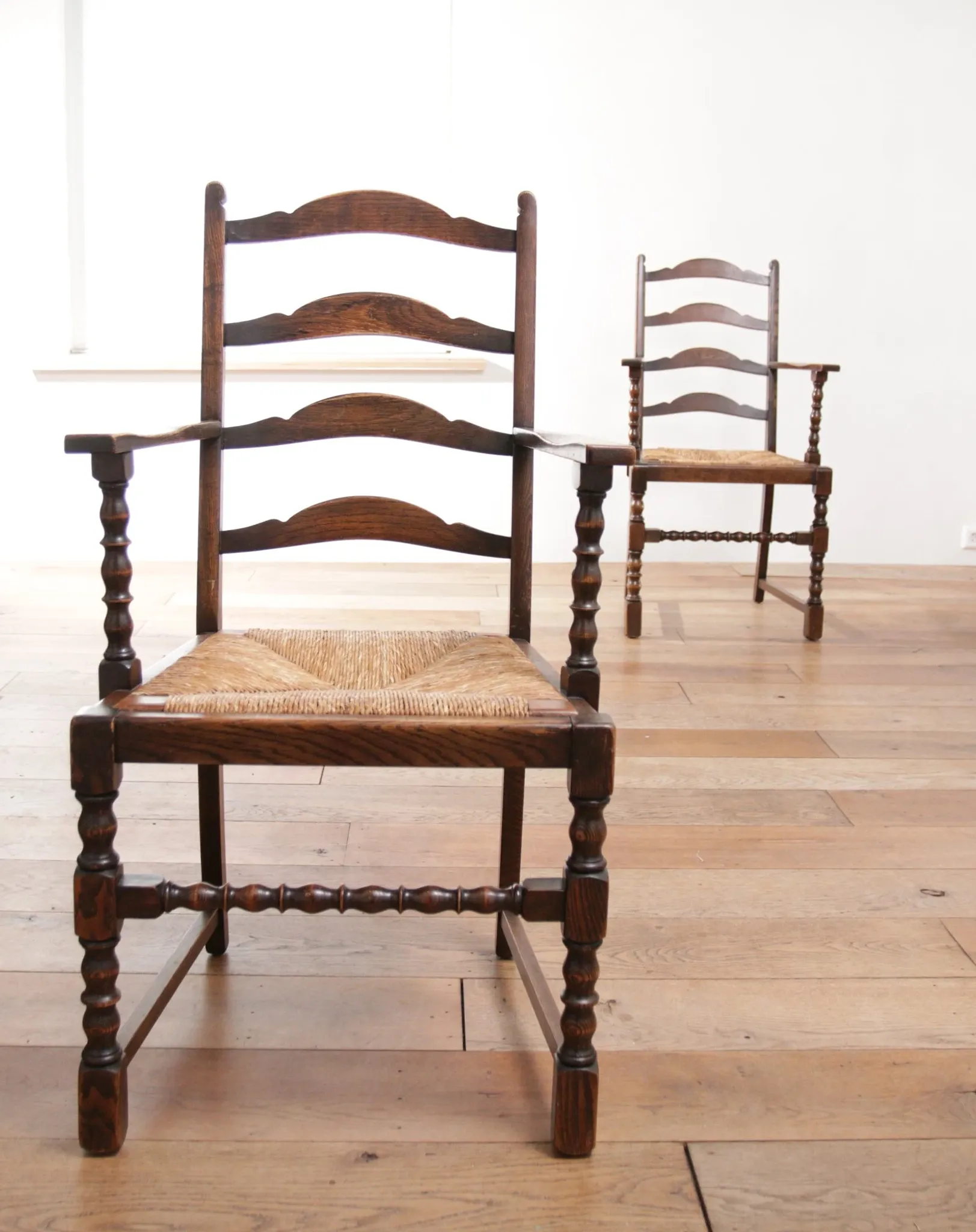 Pair of English oak armchairs with ladder back and rush seats