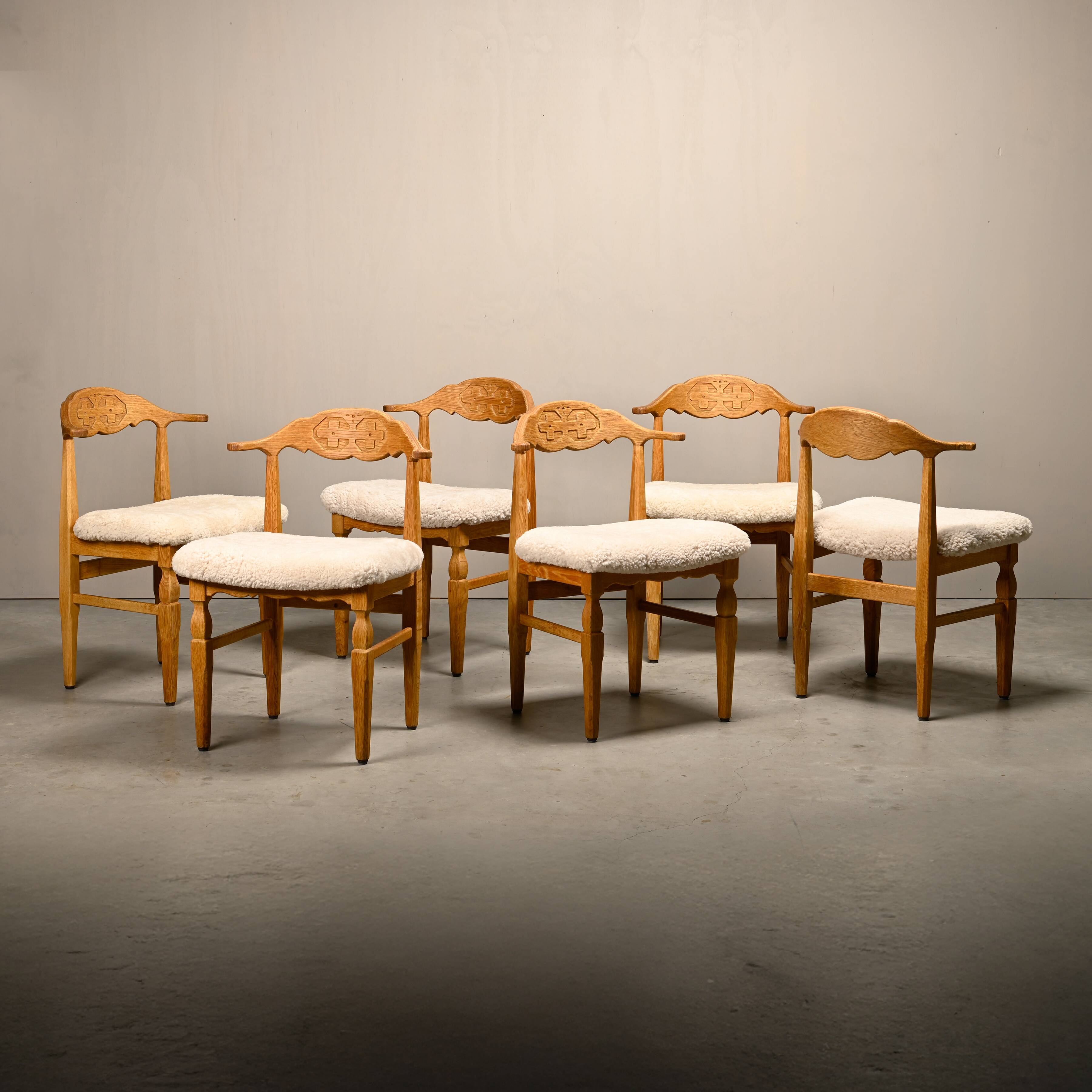 Henning Kjærnulf dining chairs set in Oak and Sheepskin, Denmark, 1960s