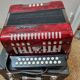 Red Aidi R accordion in his suitcase