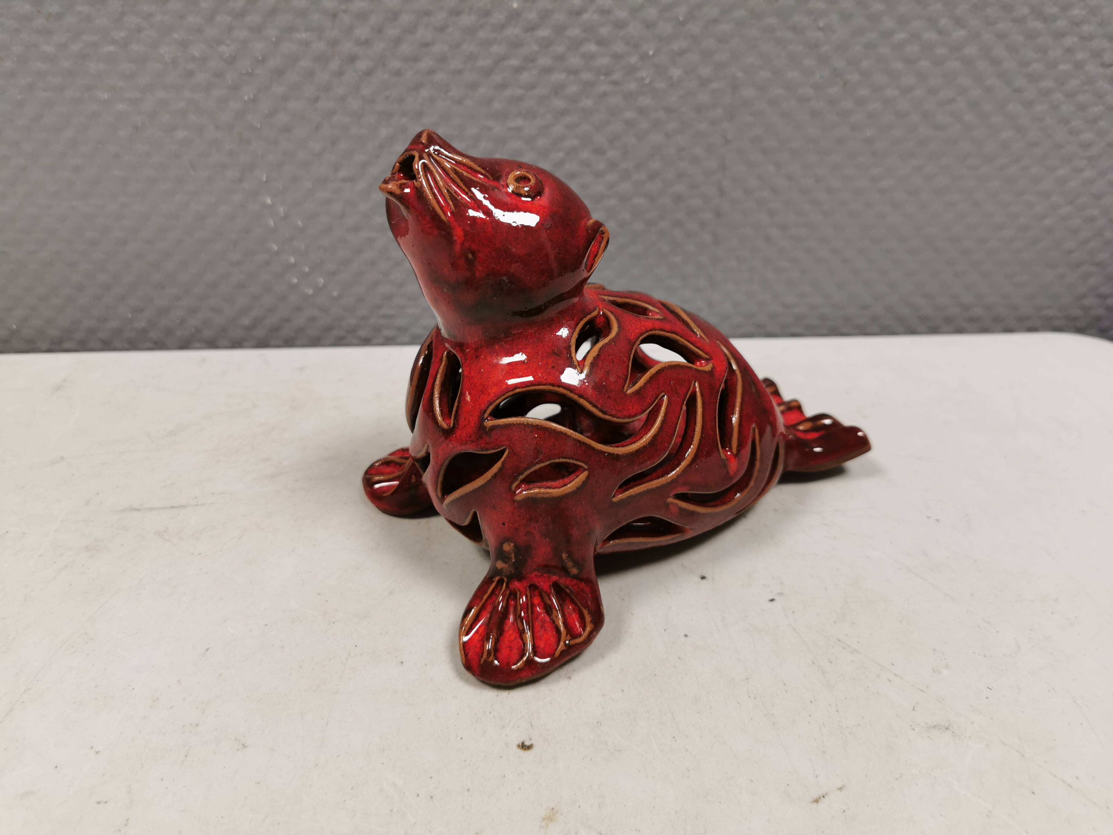 Beautiful seal in ceramic with metallic red glaze.