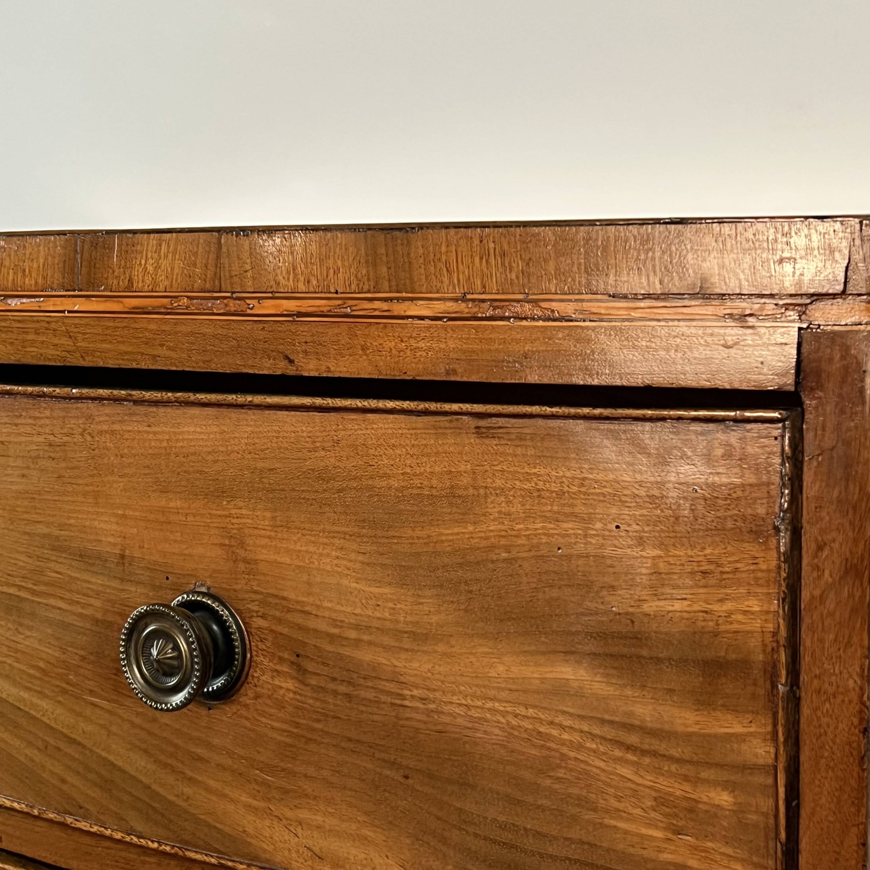 English commode from the George III Regency period, bombe shape in mahogany veneer.