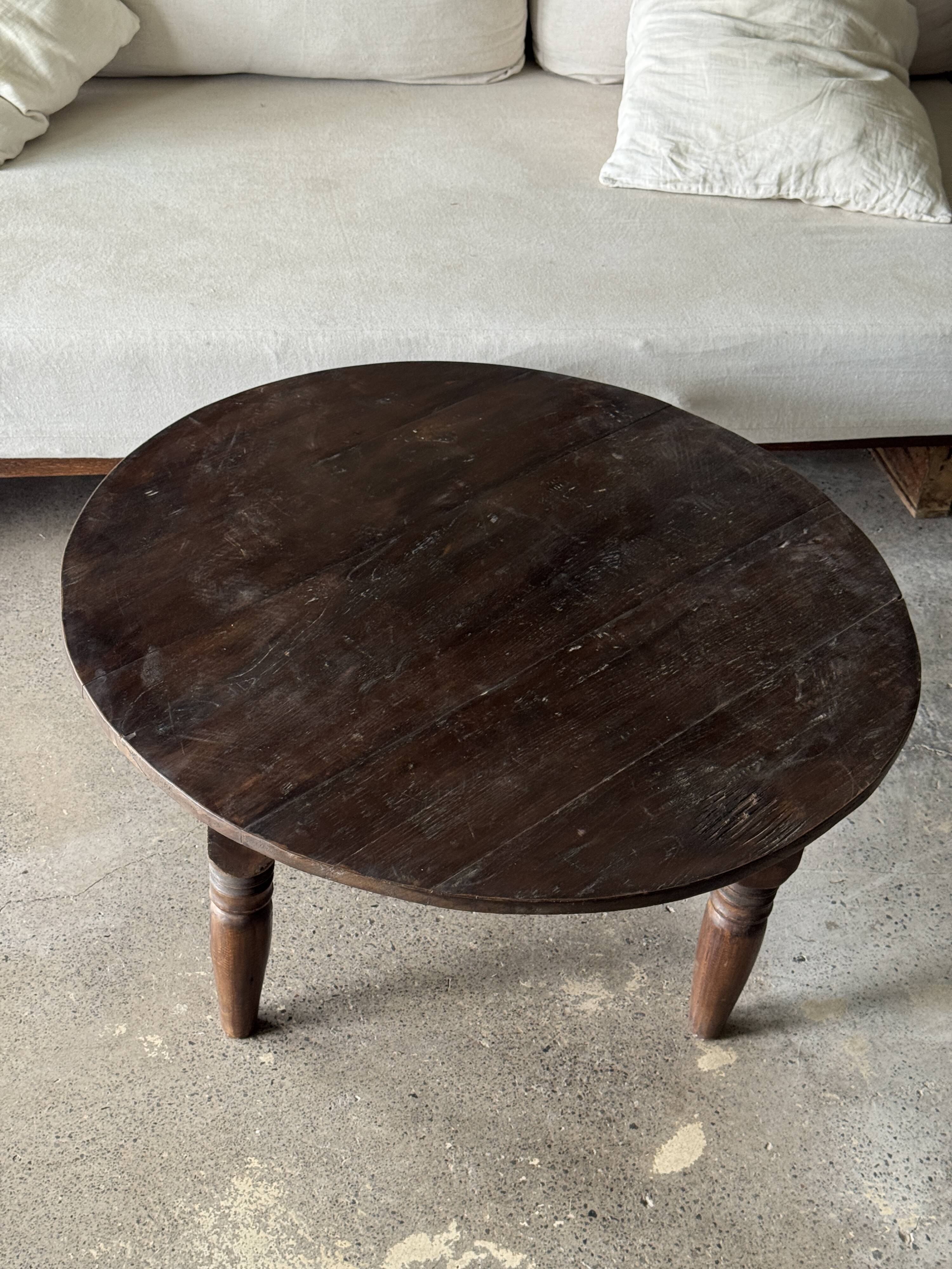 Coffee table, round antique Indonesian teak table with straight legs.