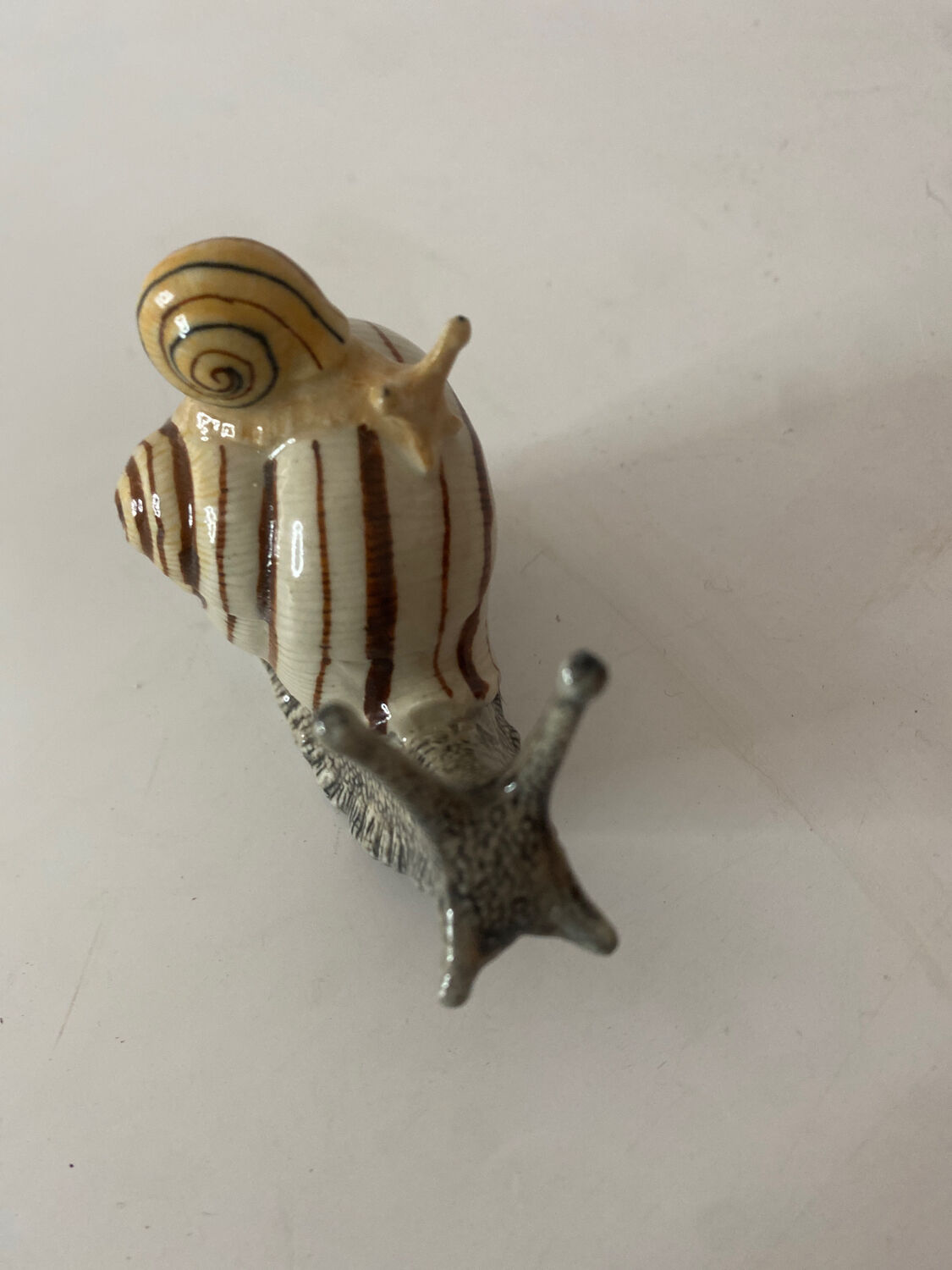 Porcelain figurine snail and its small