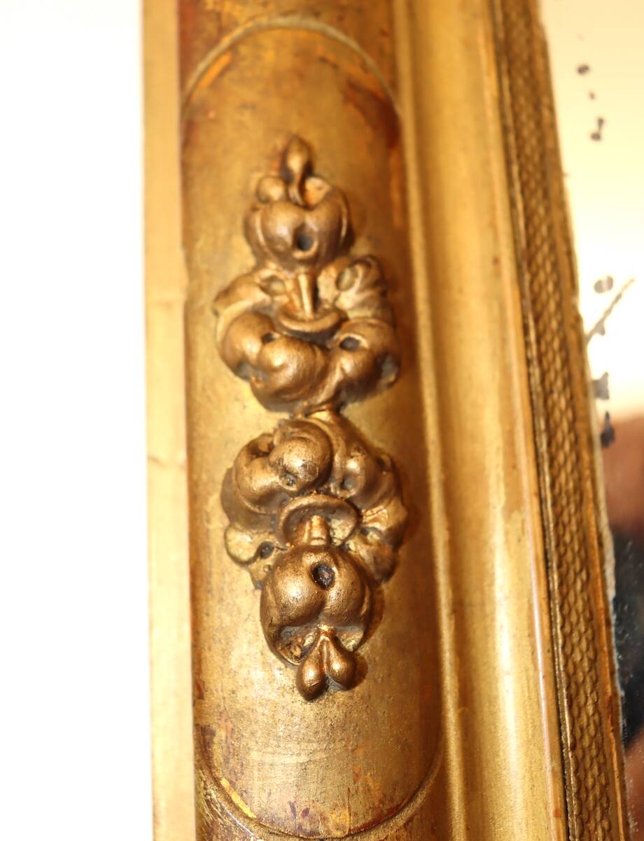 Rectangular mirror in gilded wood with relief decoration of flowers.
