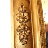 Rectangular mirror in gilded wood with relief decoration of flowers.