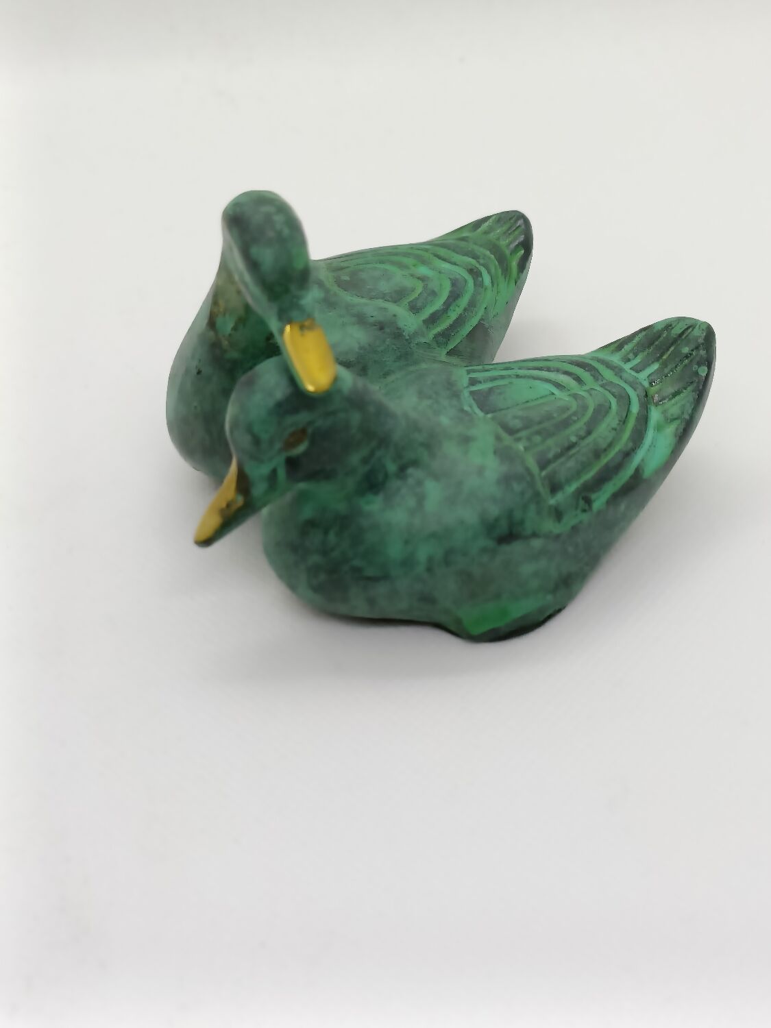 Two green and golden ducks in brass