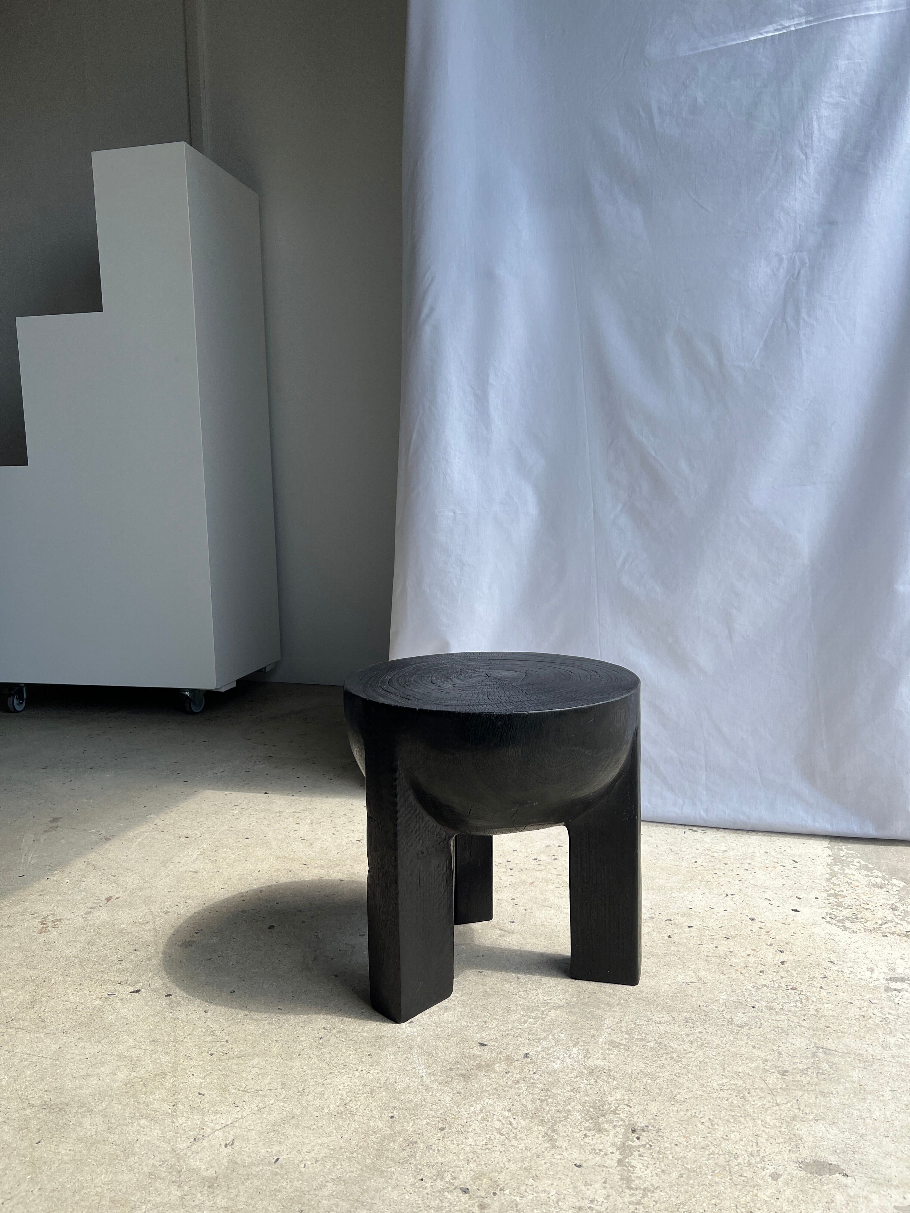 Black mango wood tripod side table with a semi-spherical top, height: 45 cm, diameter: 44 cm.