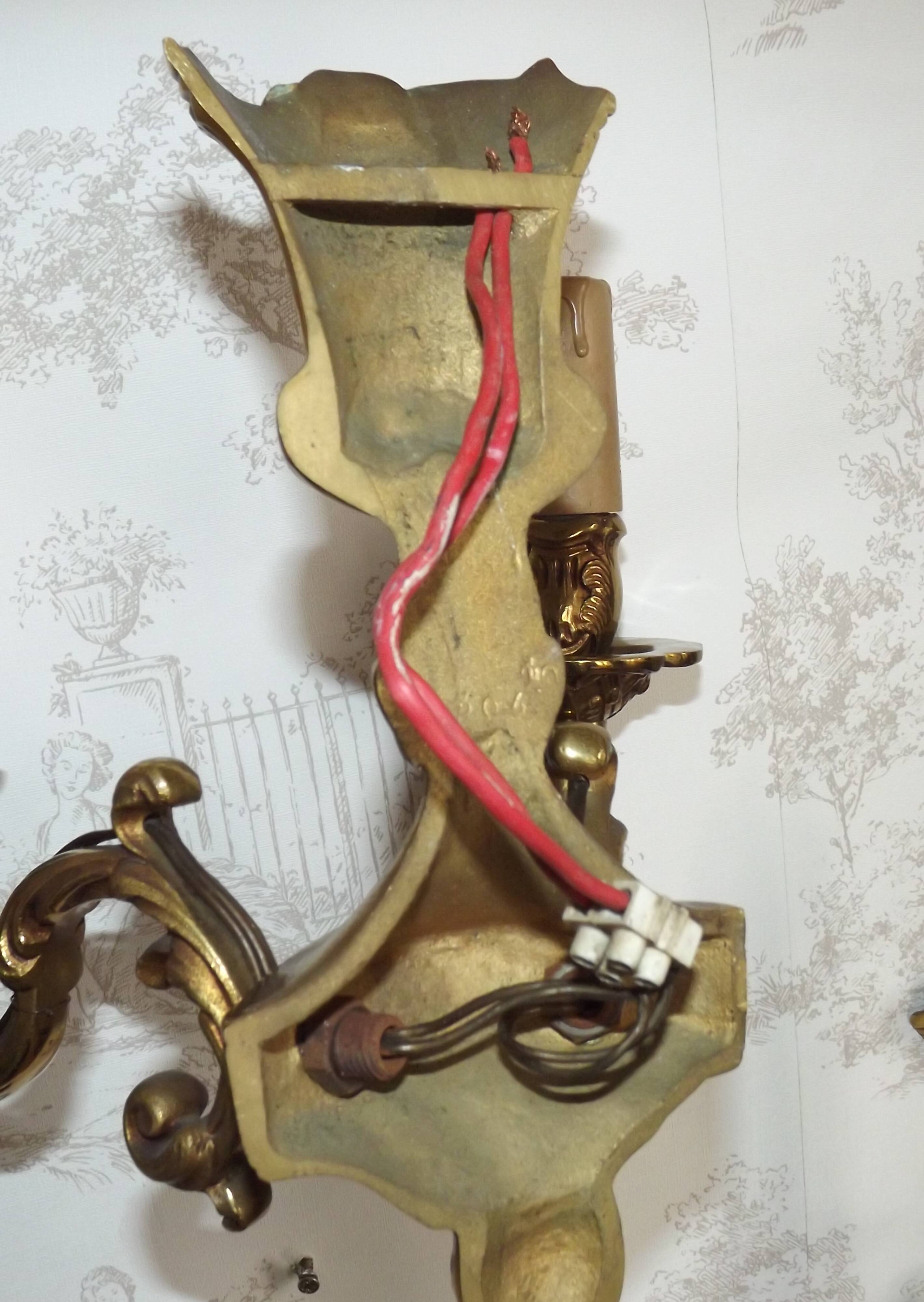 Pair of French baroque brass wall sconces with two branches, decorated with acanthus and wickerwork.