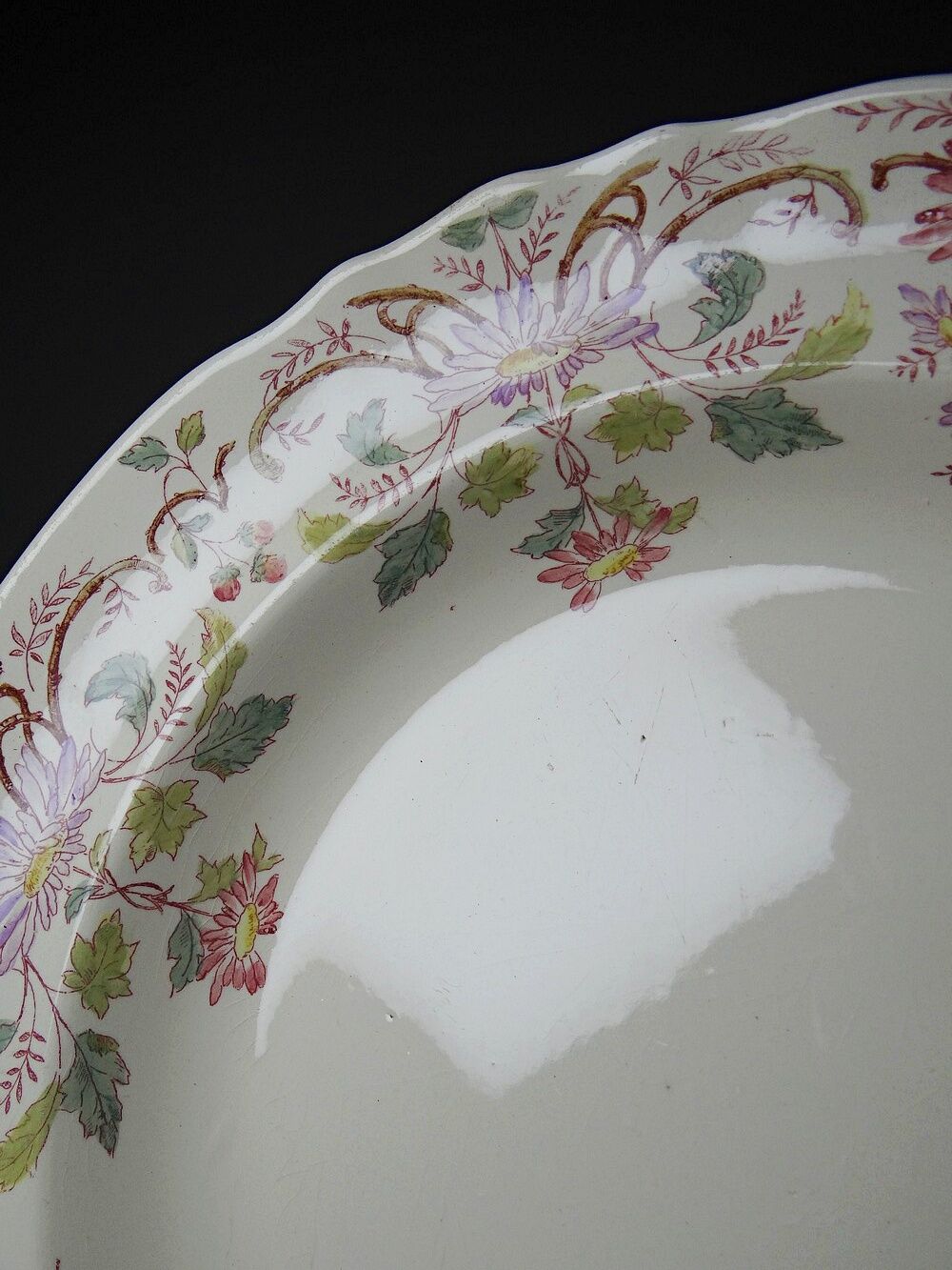 Antique Longchamp service shallow dish with polychrome daisies, ironstone, 19th century.