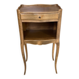 A bedside table with a drawer and a niche in Louis XV style.