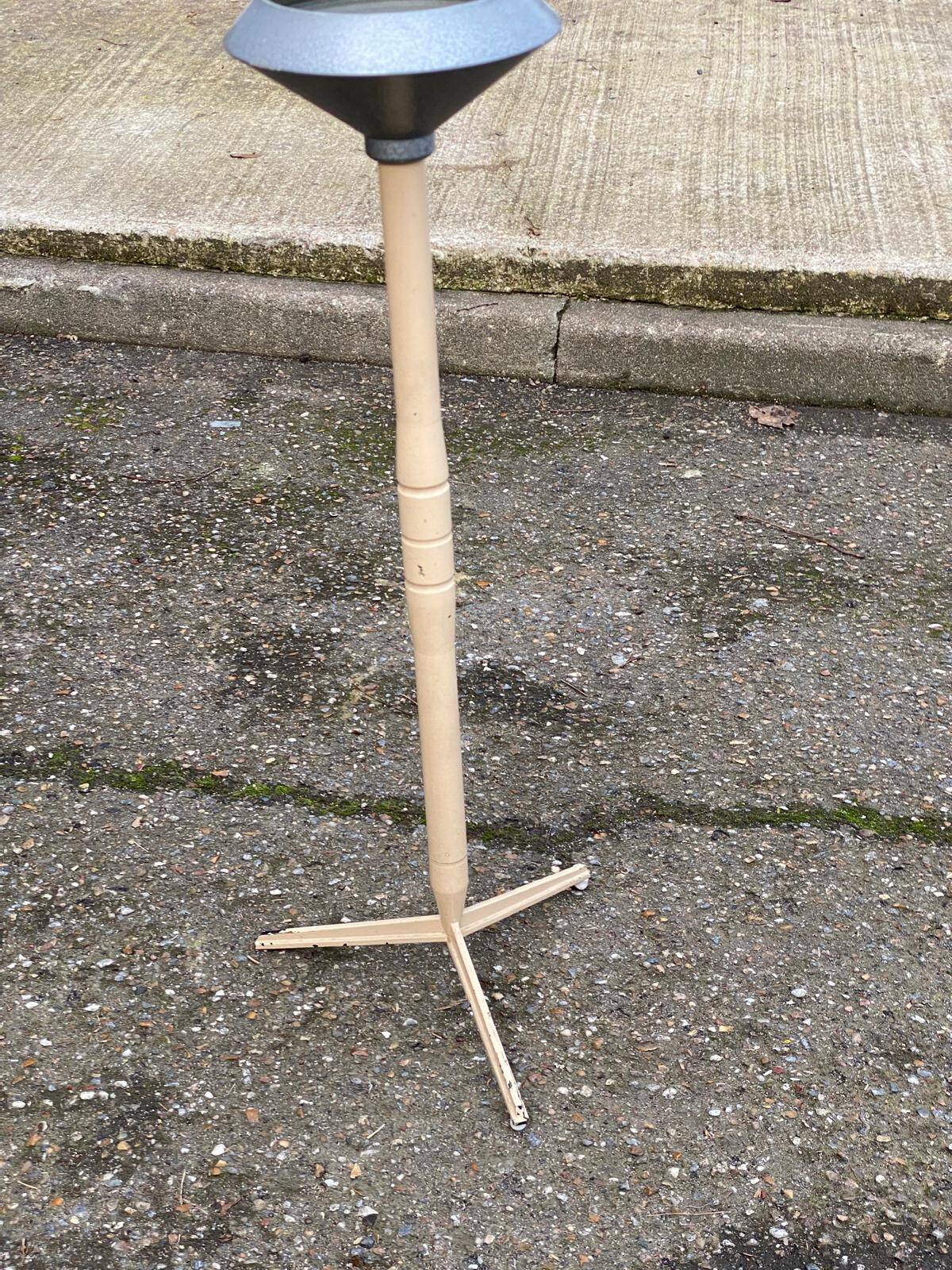 Vintage ashtray on a beige and grey metal stand.