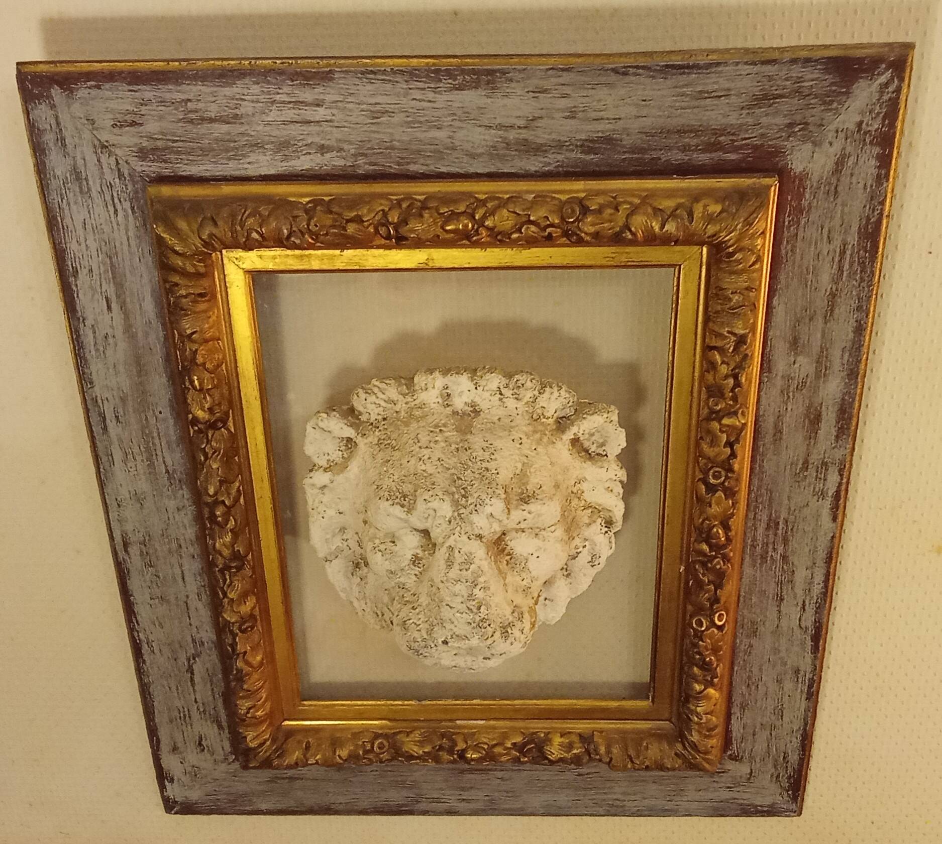 Antique gilded frame with stone lion head ornament on plexiglass