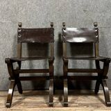 Pair of medieval style chairs in solid wood and leather, 19th century, circa 1850