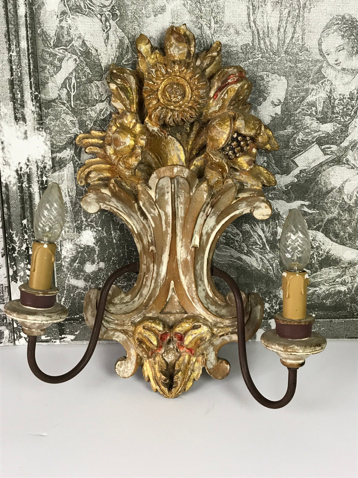 Paire d'appliques a 2 lumières en bois sculpté et patiné à décor de fleurs