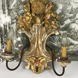 Paire d'appliques a 2 lumières en bois sculpté et patiné à décor de fleurs